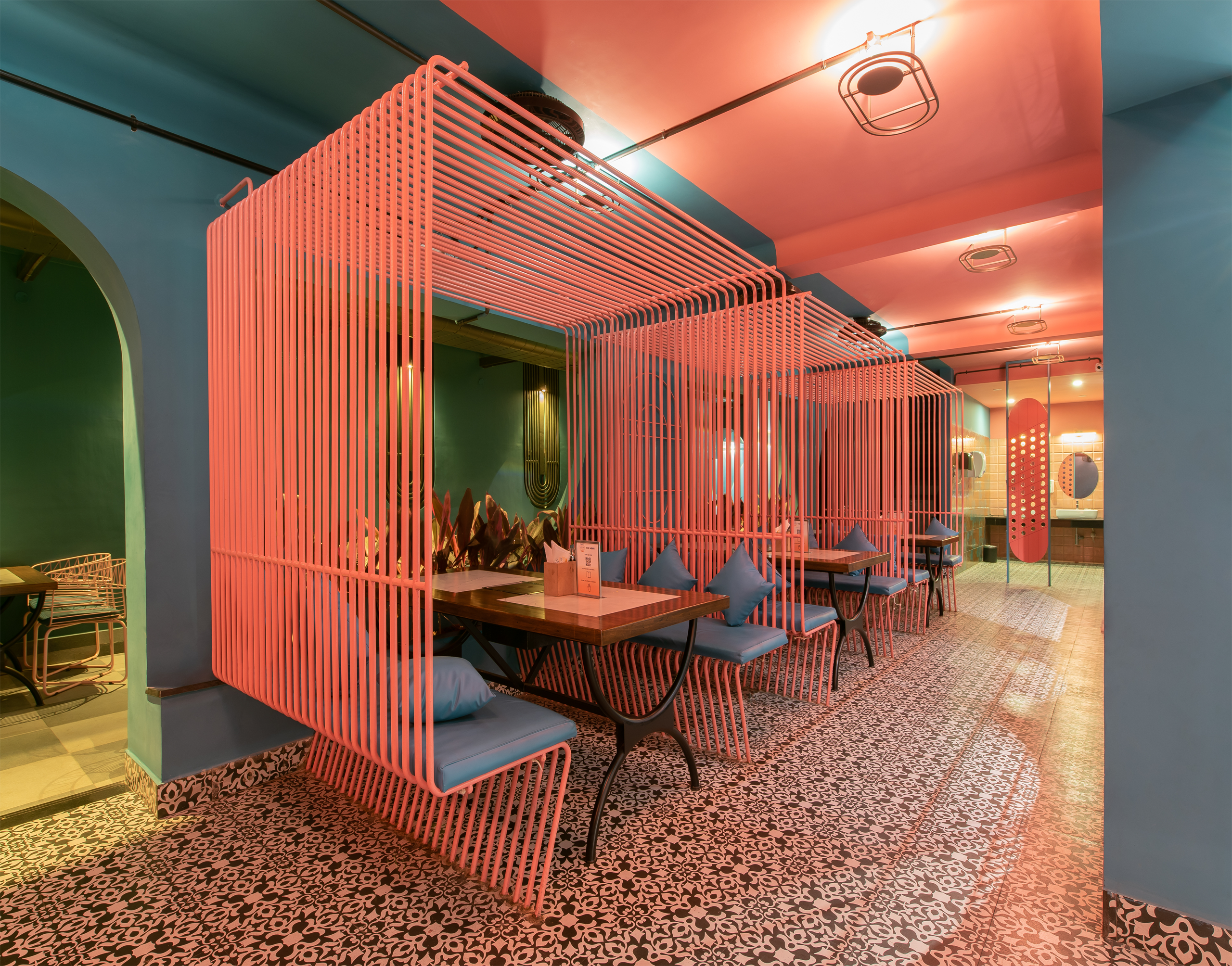 Gustoes dining area with red linear booths, teal seating and patterned floor