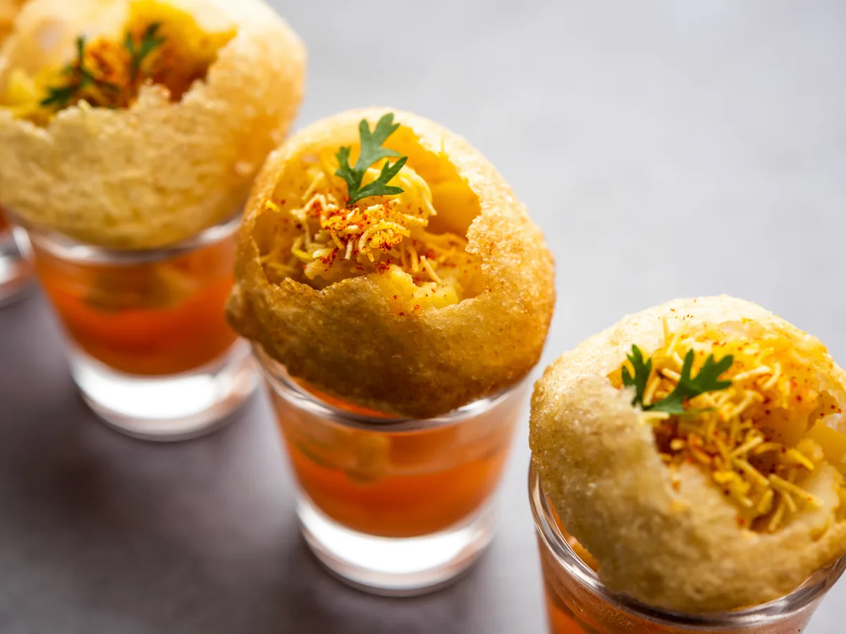 Panipuri arranged with flavoured water at a live chaat counter